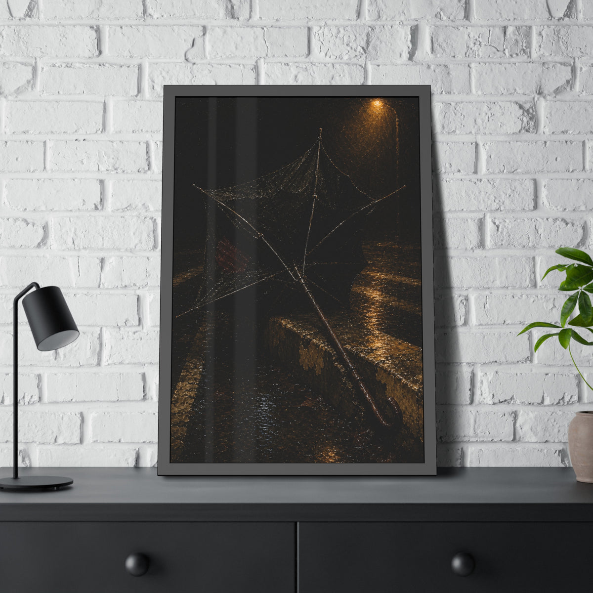 A broken umbrella inside out on a wet curb under a street lamp. The Inversion at the Median by Garabaggio, framed fine art print hanging in a room.