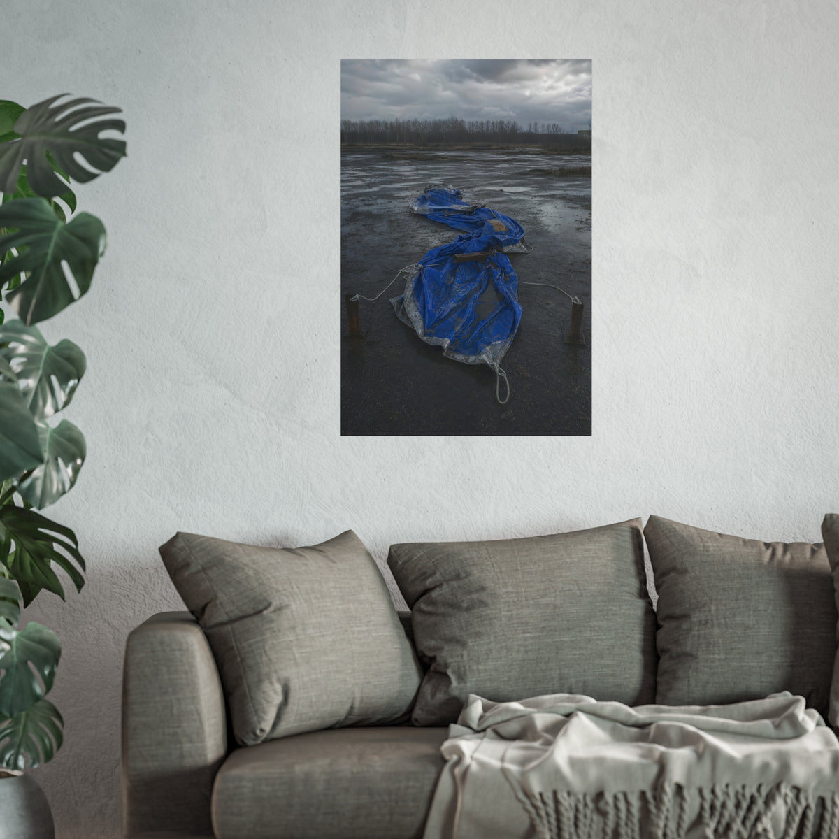 Collapsed blue tarp roped between two posts on wet cracked ground. Collapse Under Wind by Garabaggio, fine art print hanging in a room.