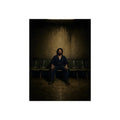 A man sits in the middle of a row of empty chairs under a wall light. Garabaggio Takes the Middle Chair by Garabaggio, fine art print, 12″ x 16″.