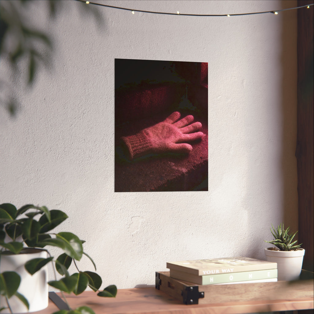 A knitted glove lying flat on a concrete step under pink light. The Vigil in Pink Light by Garabaggio, fine art print hanging in a room.