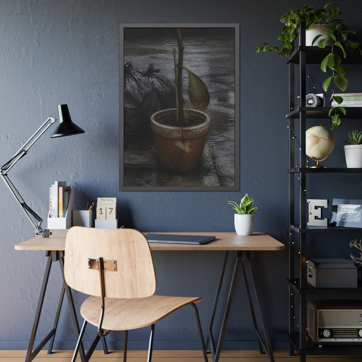 A taped clay pot with one leaf and a green shoot on wet pavement. The Green at the Base by Garabaggio, framed fine art print hanging in a room.