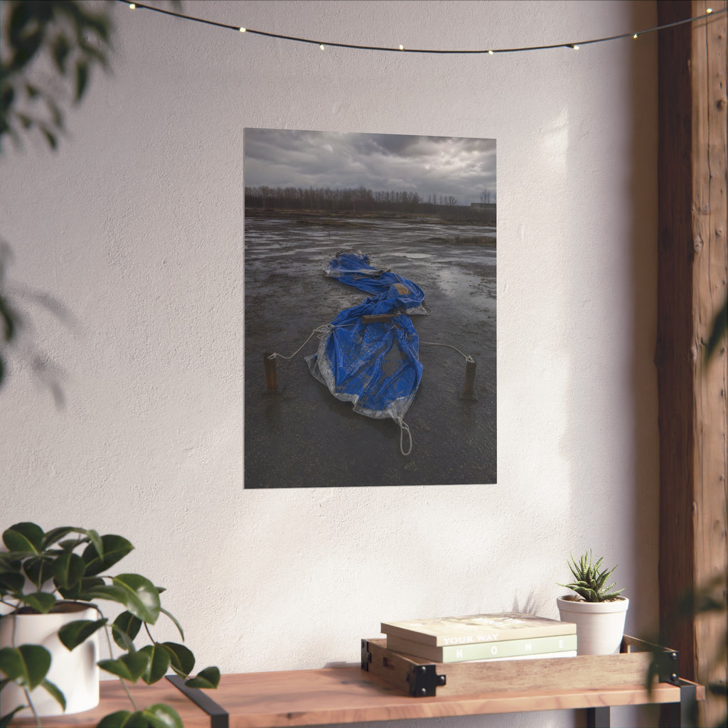 Collapsed blue tarp roped between two posts on wet cracked ground. Collapse Under Wind by Garabaggio, fine art print hanging in a room.