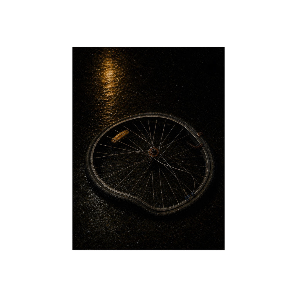 A buckled bicycle wheel on wet asphalt beneath a streetlight reflection. The Bend from Impact by Garabaggio, fine art print, 12″ x 16″.