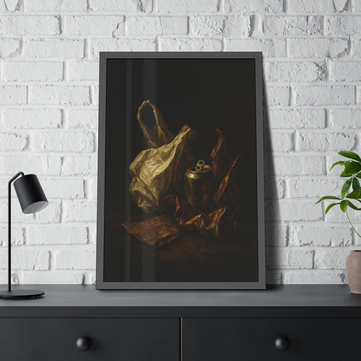 A crumpled plastic bag, crushed can and foil wrappers on a dark table. The Pietà of the Deflated by Garabaggio, framed fine art print hanging in a room.