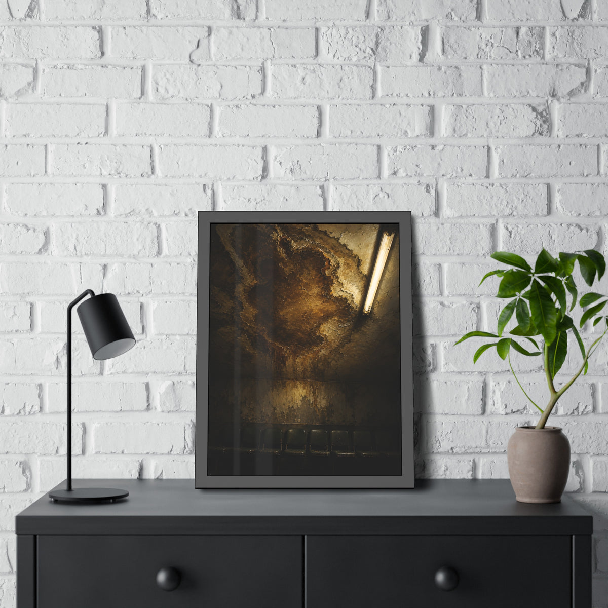 A brown water stain spreading across a ceiling above a row of chairs. The Stain Above the Row by Garabaggio, framed fine art print hanging in a room.