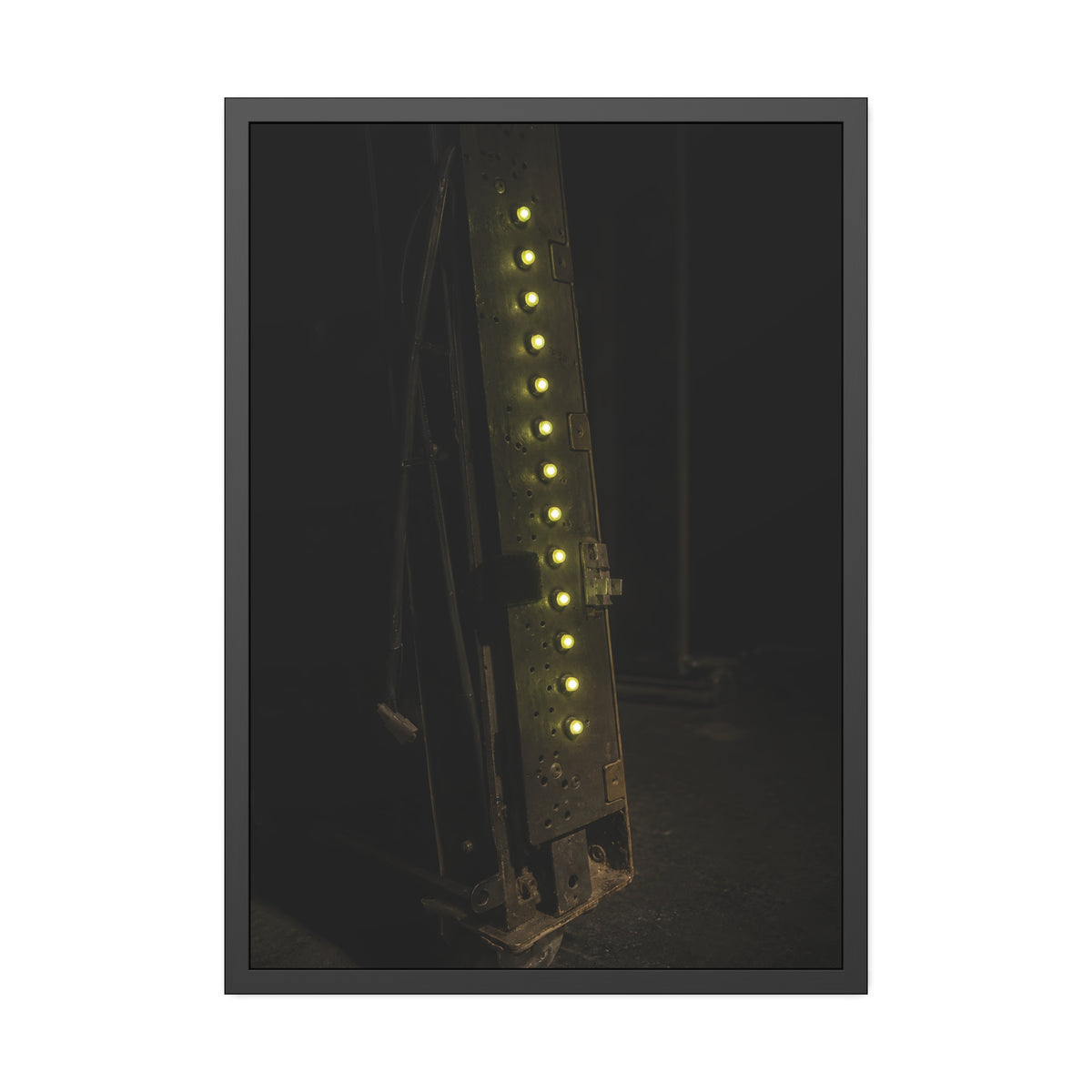 A dark rack panel with a vertical row of glowing green indicator lights. The First Green Choir by Garabaggio, framed fine art print, 28″ x 40″.