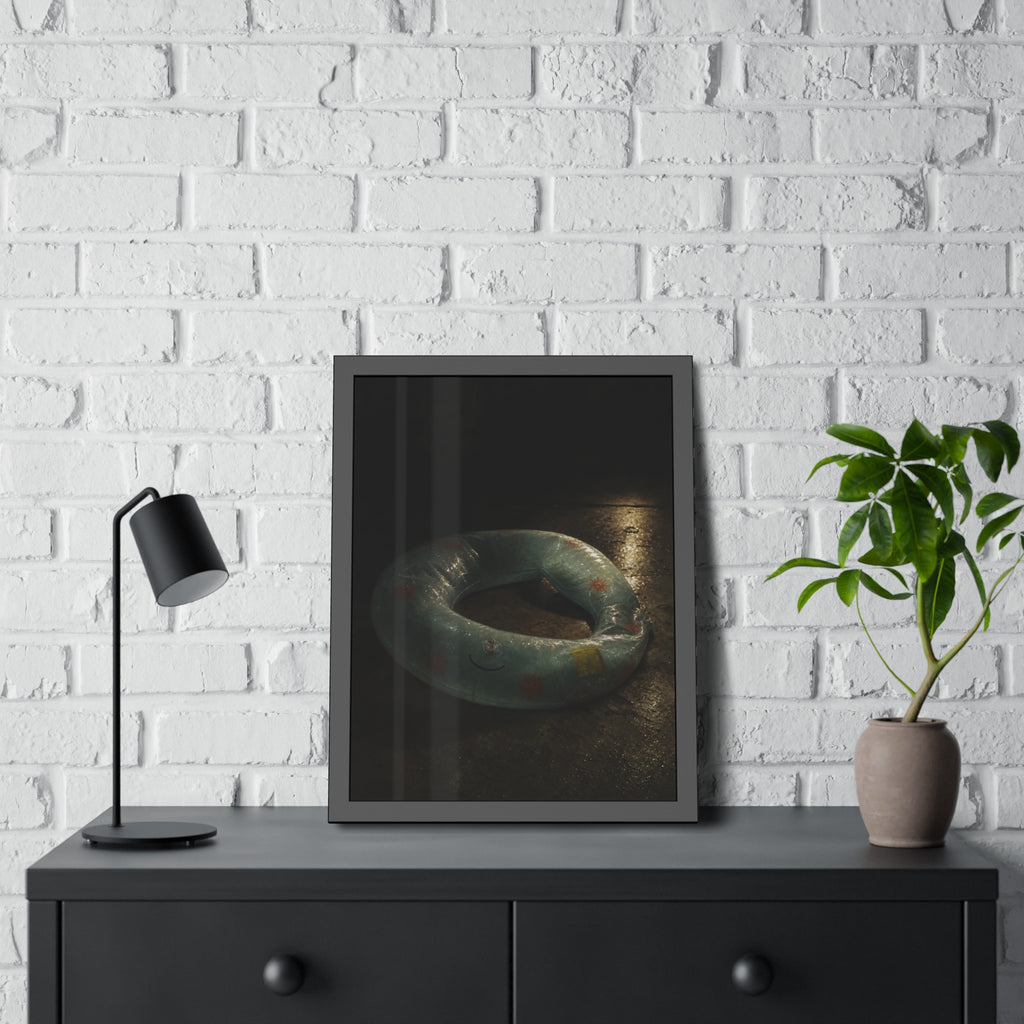 Deflated pool float ring on wet ground, lit from one side in the dark. After the Last Swim by Garabaggio, framed fine art print hanging in a room.