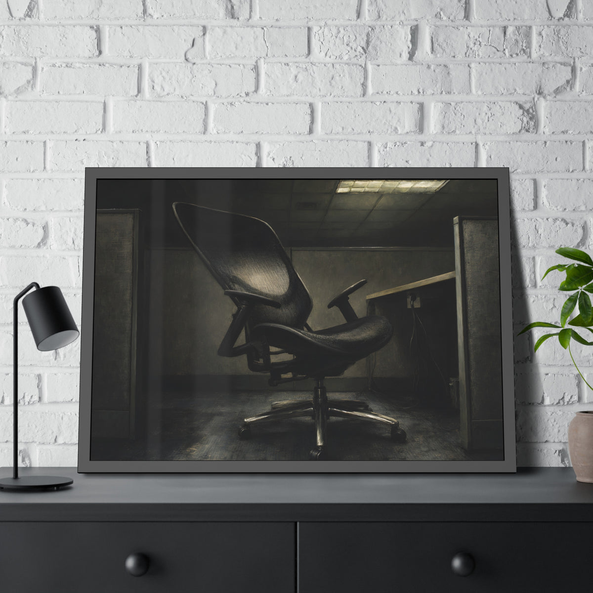 An office chair tilted back in an empty cubicle under one ceiling light. The Ergonomic Chair, Unlocked by Garabaggio, framed fine art print hanging in a room.