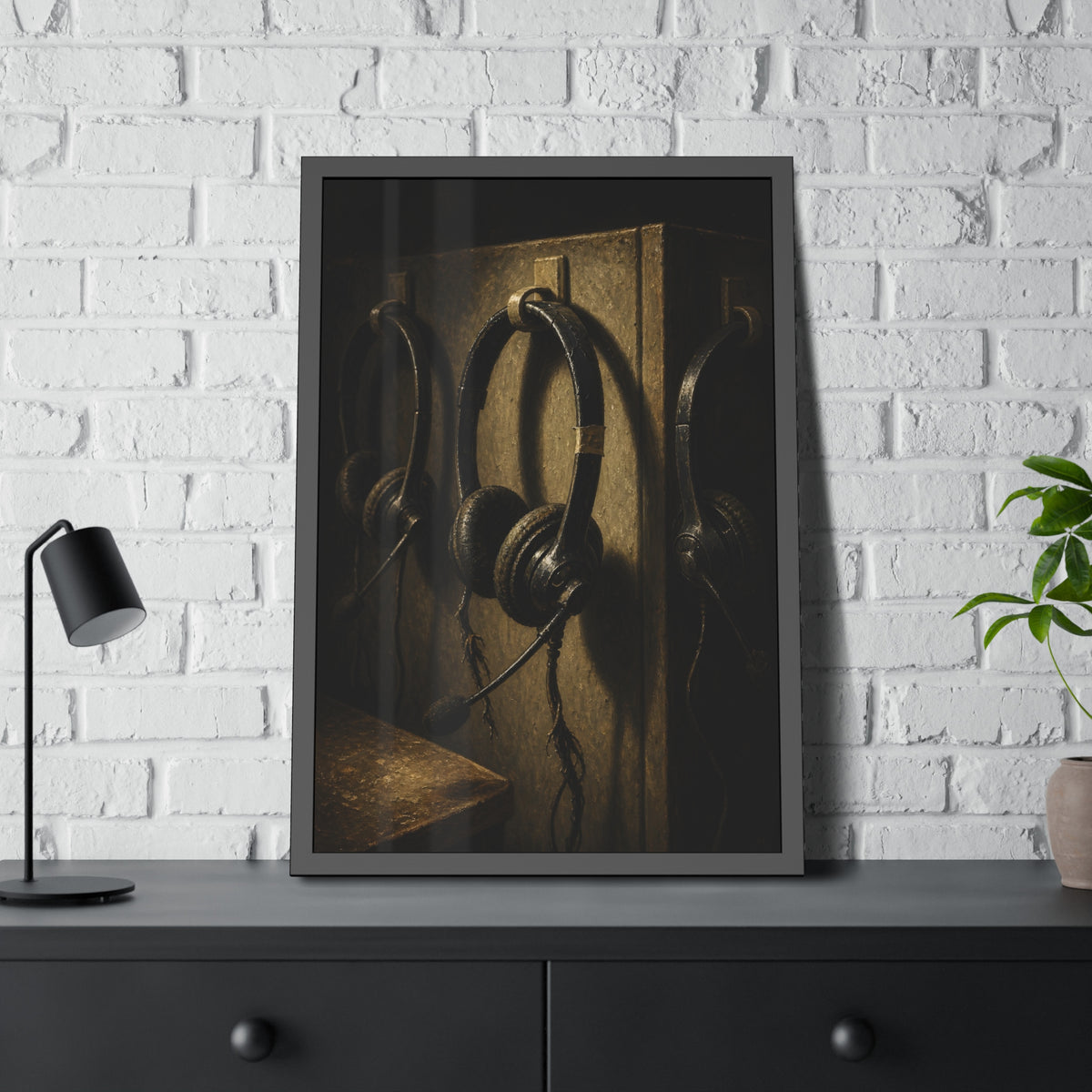 Three worn call center headsets hanging on wall hooks in dim light. The Headsets Left Hanging by Garabaggio, framed fine art print hanging in a room.