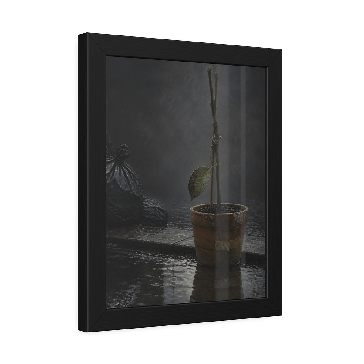 Bare tied stems in a clay pot on flooded pavement, one leaf remaining. The Grey Between by Garabaggio, framed fine art print hanging in a room.