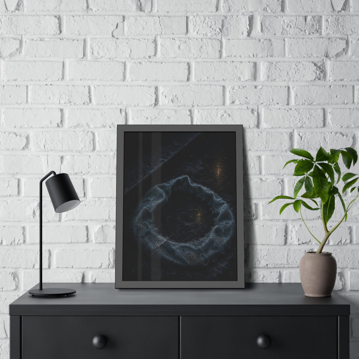 A deflated ring float collapsed on wet pavement under distant amber light. The Freezing of the Smile by Garabaggio, framed fine art print hanging in a room.