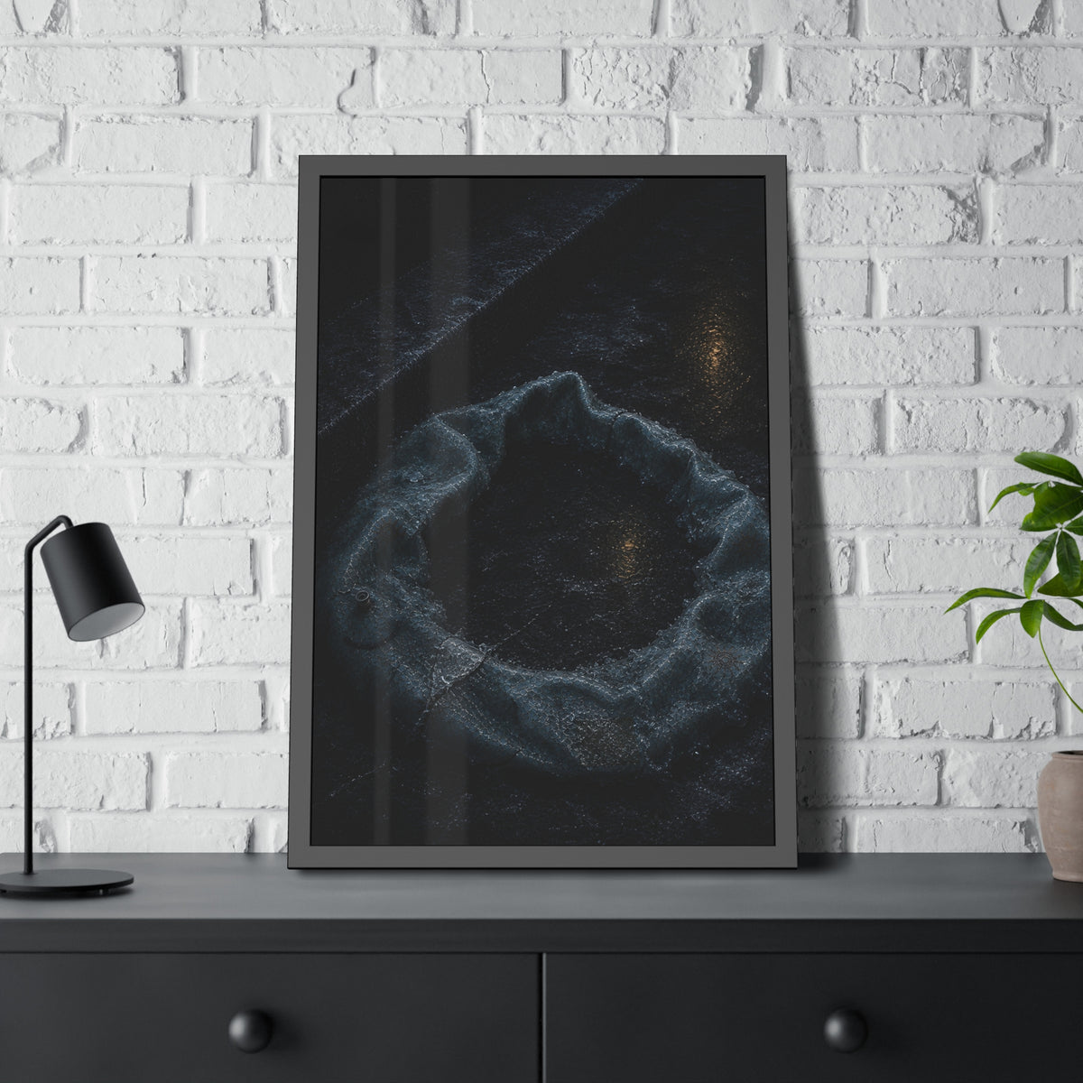 A deflated ring float collapsed on wet pavement under distant amber light. The Freezing of the Smile by Garabaggio, framed fine art print hanging in a room.