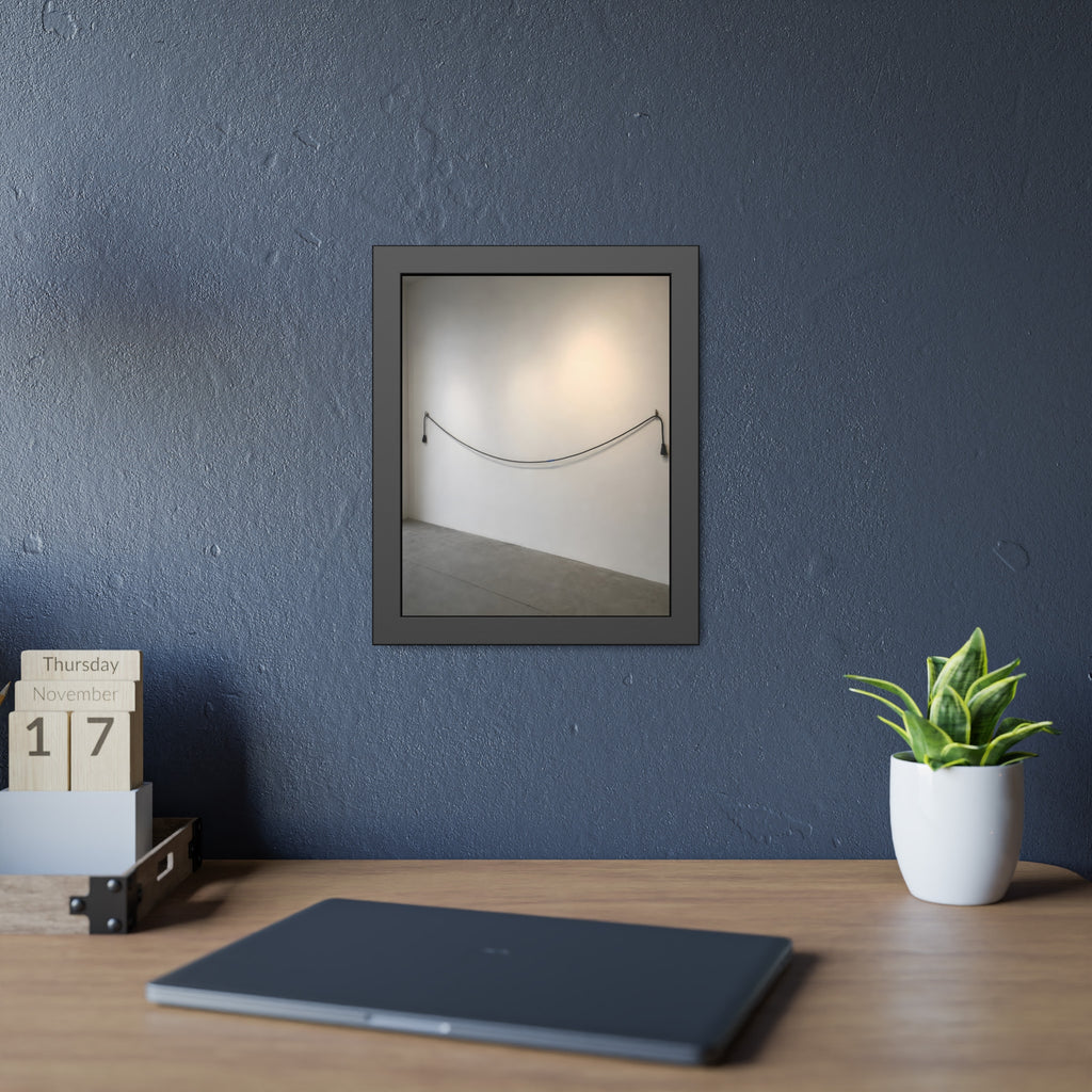 An extension cord hung in a long slack curve across a bare white wall. The Unplugged Line by Garabaggio, framed fine art print hanging in a room.