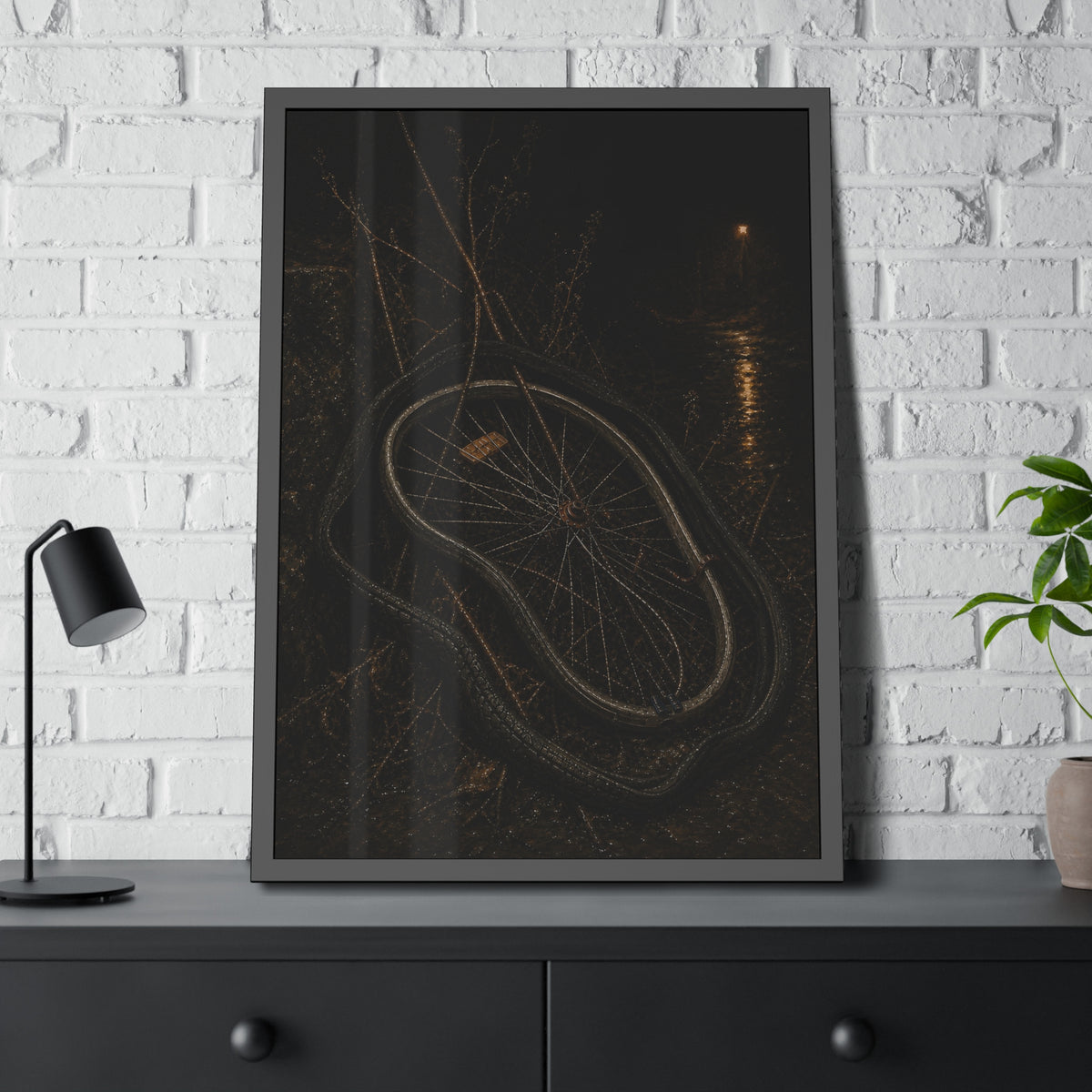 A bare bicycle wheel with its tire coiled around it on wet ground. The Removal of the Tire by Garabaggio, framed fine art print hanging in a room.
