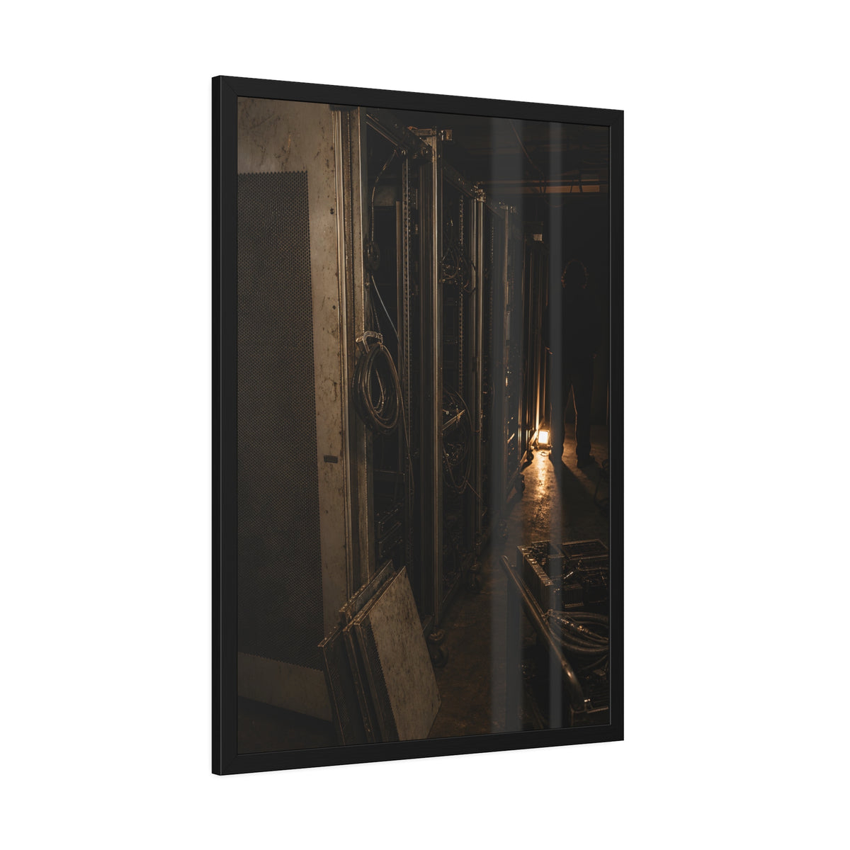 Open server racks in a dark room, a work lamp and a figure at the end. Garabaggio at the End of the Row by Garabaggio, framed fine art print hanging in a room.