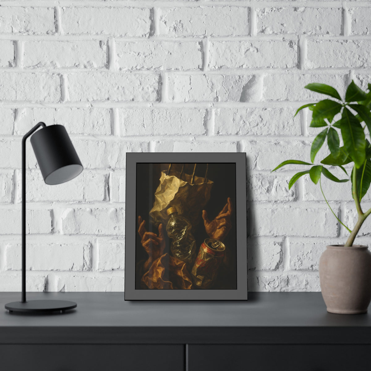 Two hands raised beside a paper bag, crushed bottle and dented can. The Assumption of the Discarded by Garabaggio, framed fine art print hanging in a room.