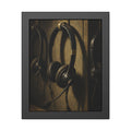 Three worn call center headsets hanging on wall hooks in dim light. The Headsets Left Hanging by Garabaggio, framed fine art print, 11″ x 14″.