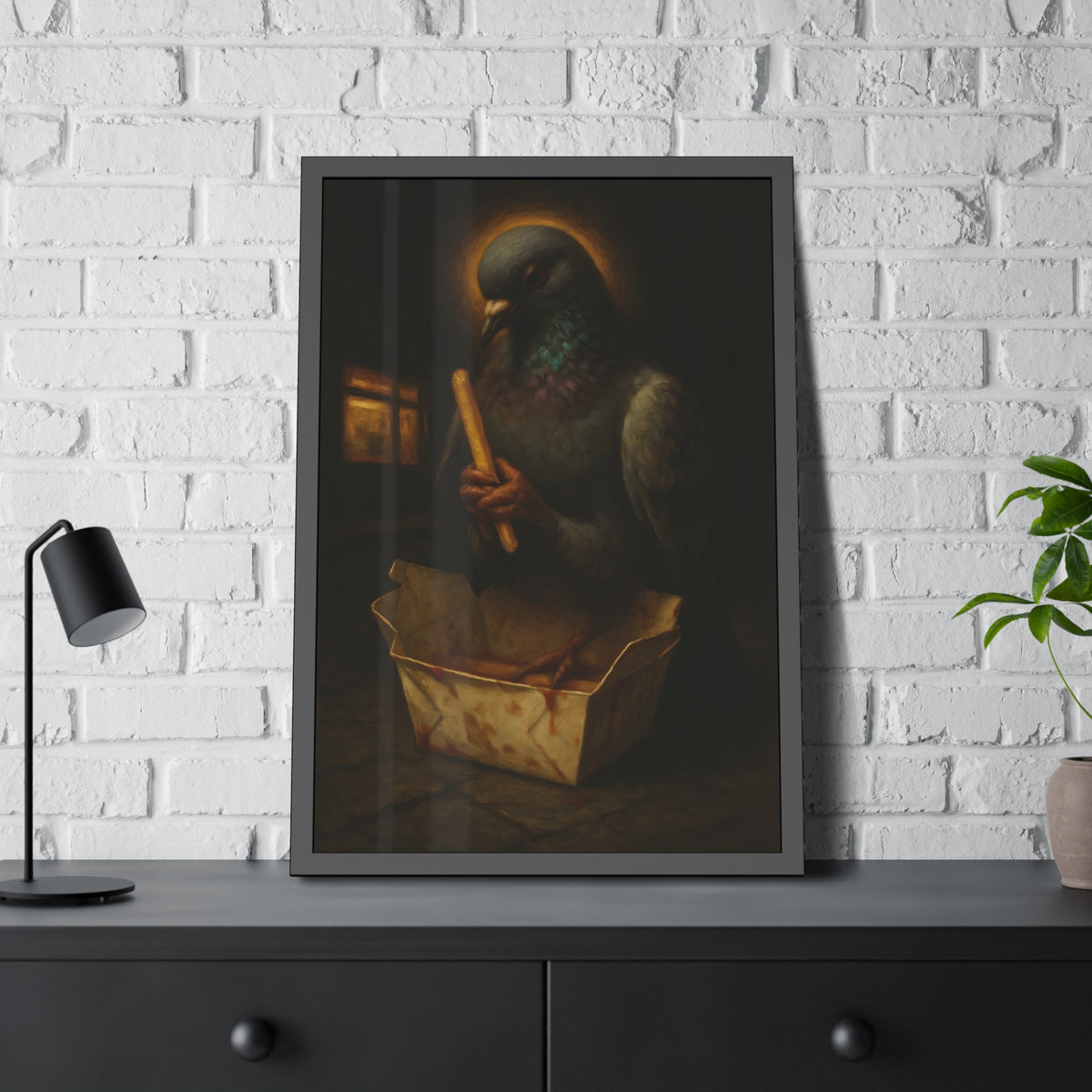 A haloed pigeon holding a french fry over a takeout carton in an alley. Madonna of the Pigeon with Fries by Garabaggio, framed fine art print hanging in a room.