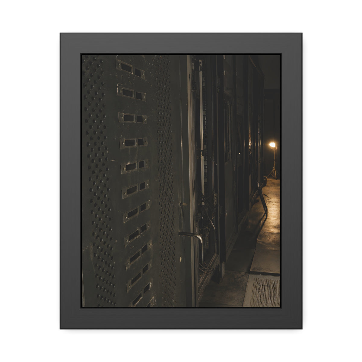 Rows of dark server cabinets with one work lamp glowing far down the aisle. Racks Without Light by Garabaggio, framed fine art print, 11″ x 14″.