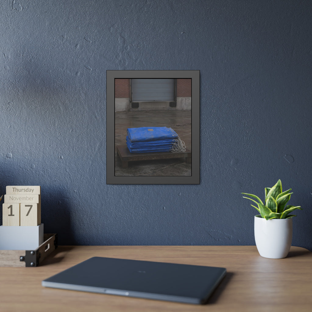A folded blue tarp stacked on a low wooden platform by a loading dock. The Repaired Fold by Garabaggio, framed fine art print hanging in a room.