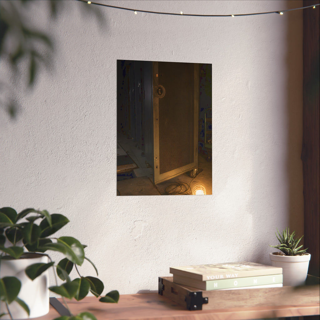 A perforated server rack door in a dark aisle lit by a floor work lamp. The Cold Aisle by Garabaggio, fine art print hanging in a room.