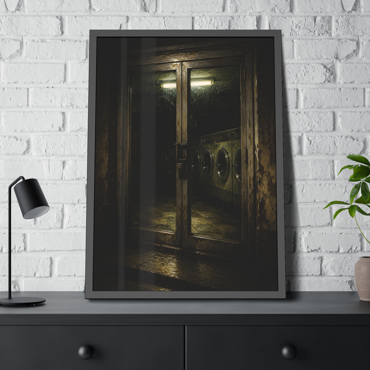 Glass laundromat doors at night with washers lit by a fluorescent tube. The Doors at Midnight by Garabaggio, framed fine art print hanging in a room.
