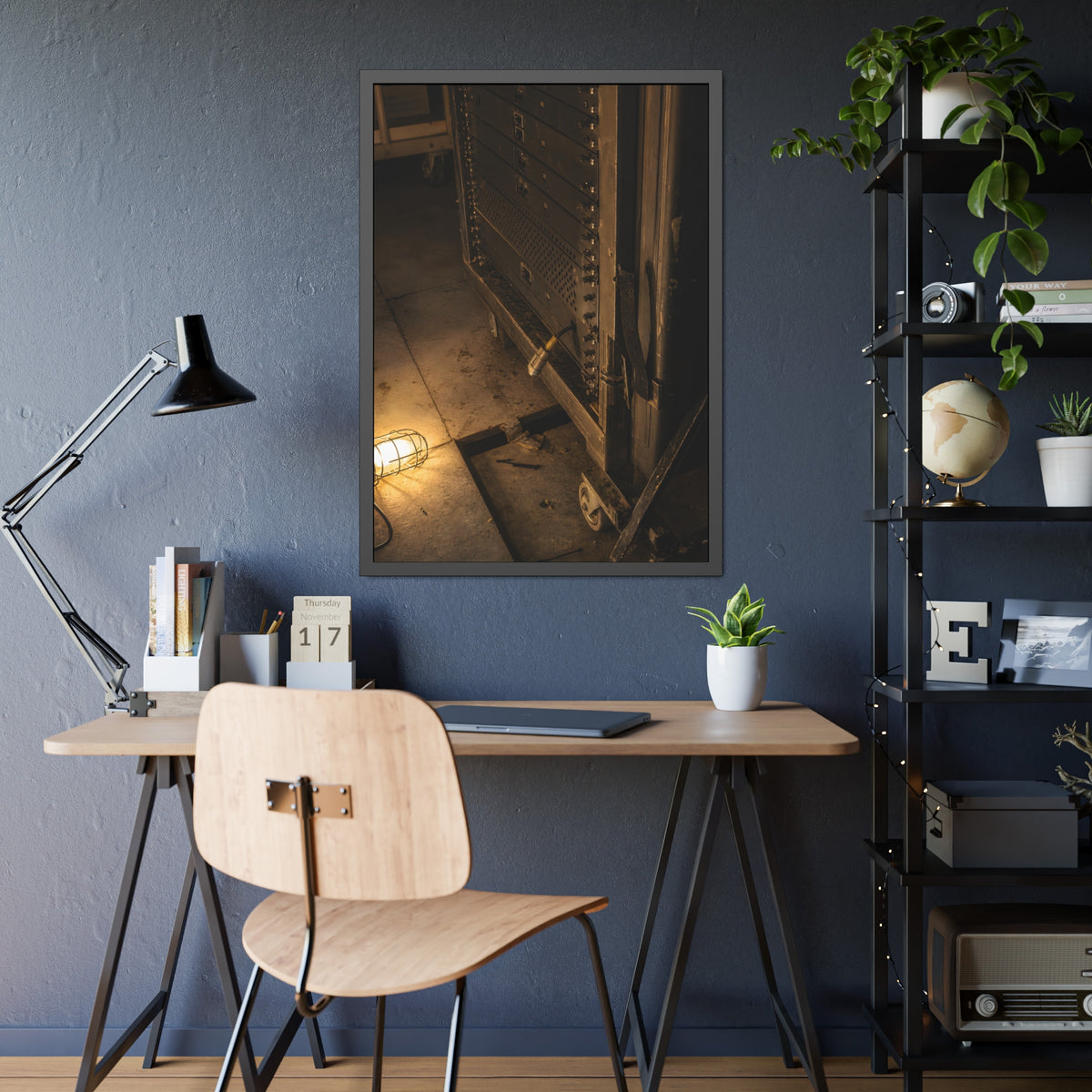 A server rack on a concrete floor beside a caged work light. The Silence at Cutover by Garabaggio, framed fine art print hanging in a room.