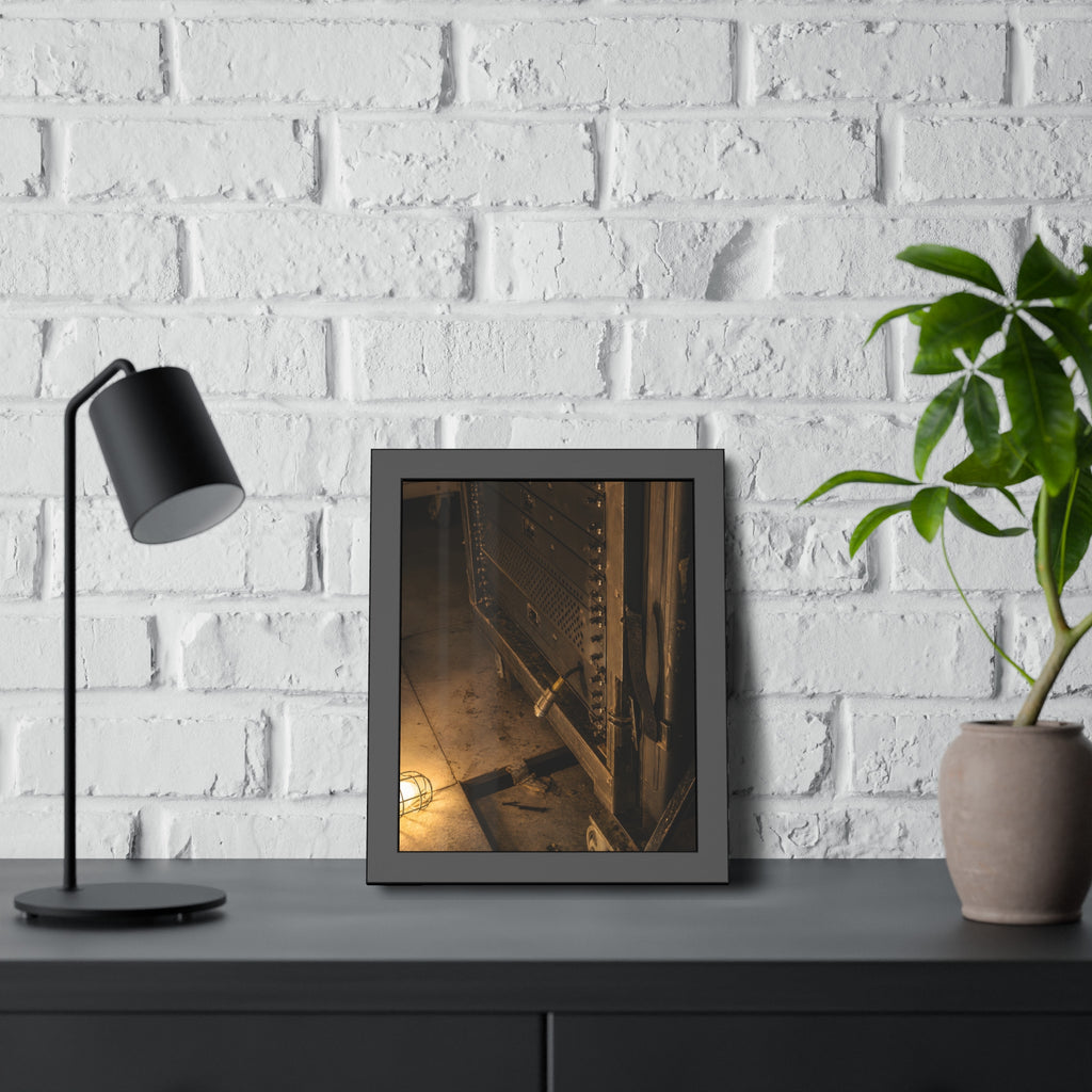 A server rack on a concrete floor beside a caged work light. The Silence at Cutover by Garabaggio, framed fine art print hanging in a room.
