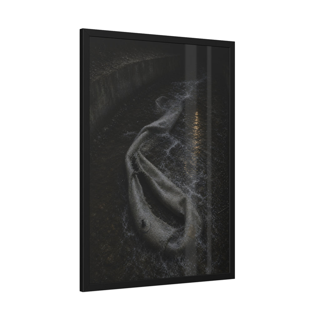 A deflated pool float caught in a concrete drainage channel of running water. The Release into Runoff by Garabaggio, framed fine art print hanging in a room.