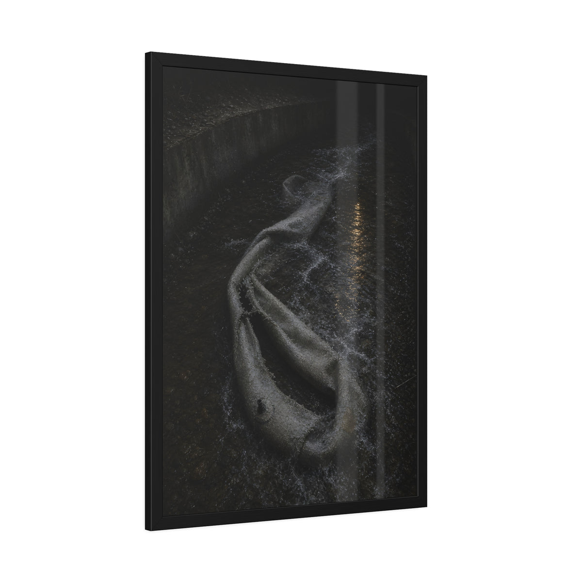A deflated pool float caught in a concrete drainage channel of running water. The Release into Runoff by Garabaggio, framed fine art print hanging in a room.