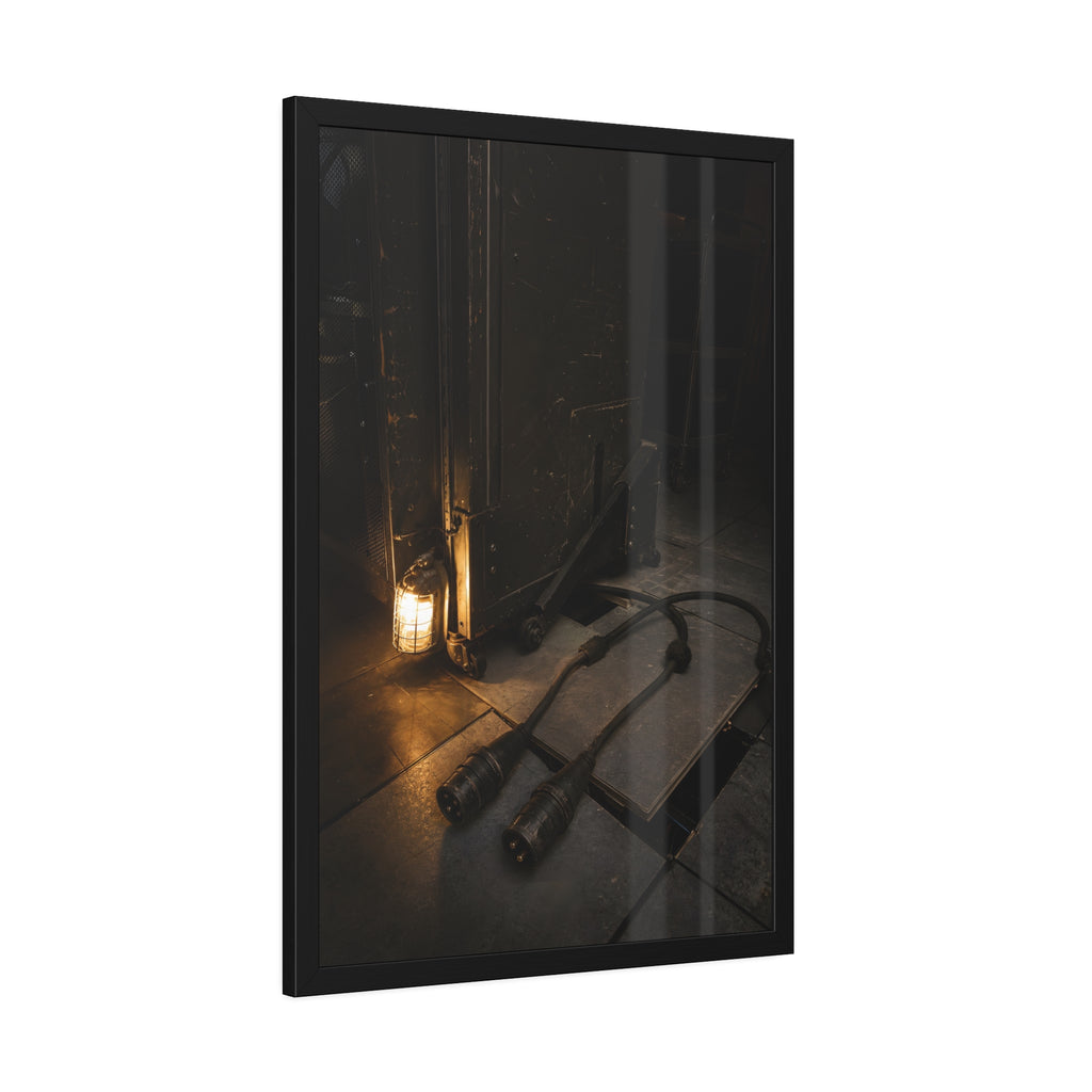 Two thick power cables unplugged on the floor beside a caged work lamp. The Redundant Power by Garabaggio, framed fine art print hanging in a room.