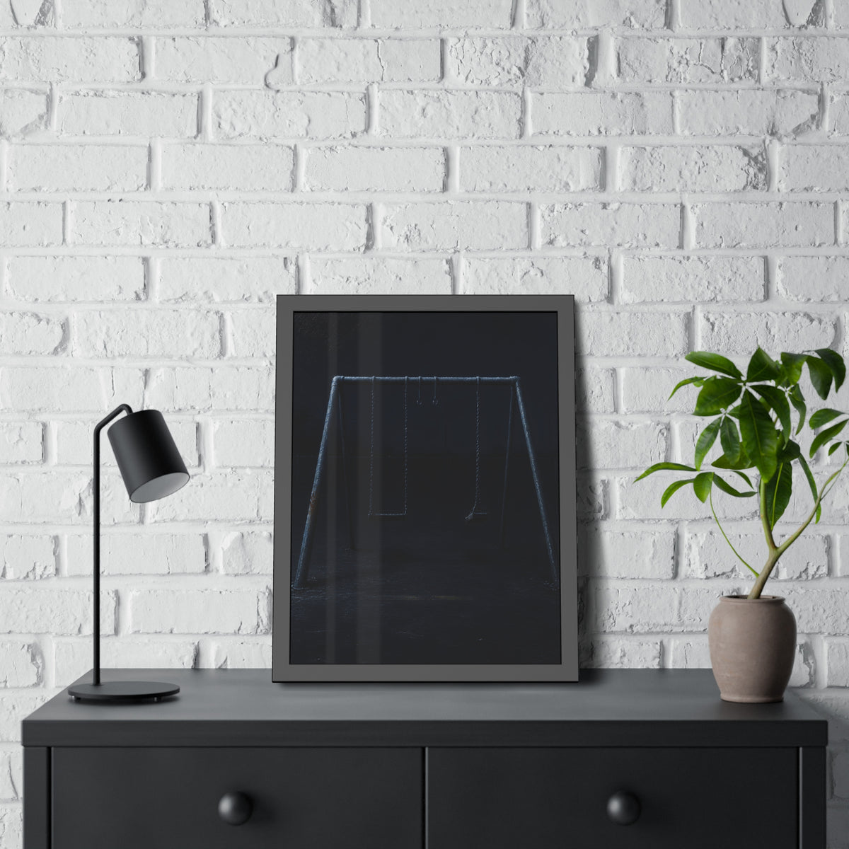 An empty swing set in near darkness with one seat twisted. The Fourth Hour: The Floodlights Cut by Garabaggio, framed fine art print hanging in a room.