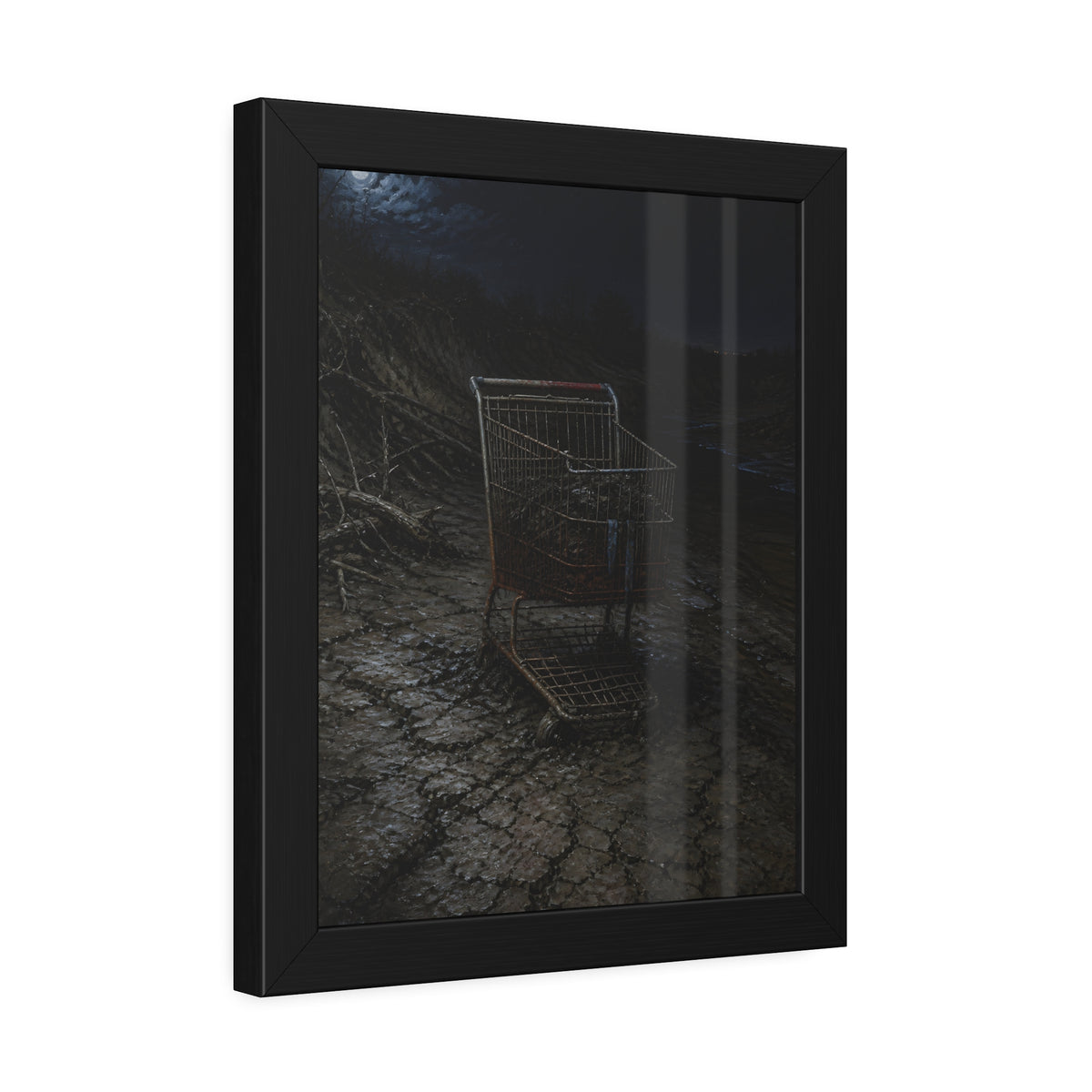A rusted shopping cart sunk in cracked dried mud under a full moon. The Silting by Garabaggio, framed fine art print hanging in a room.