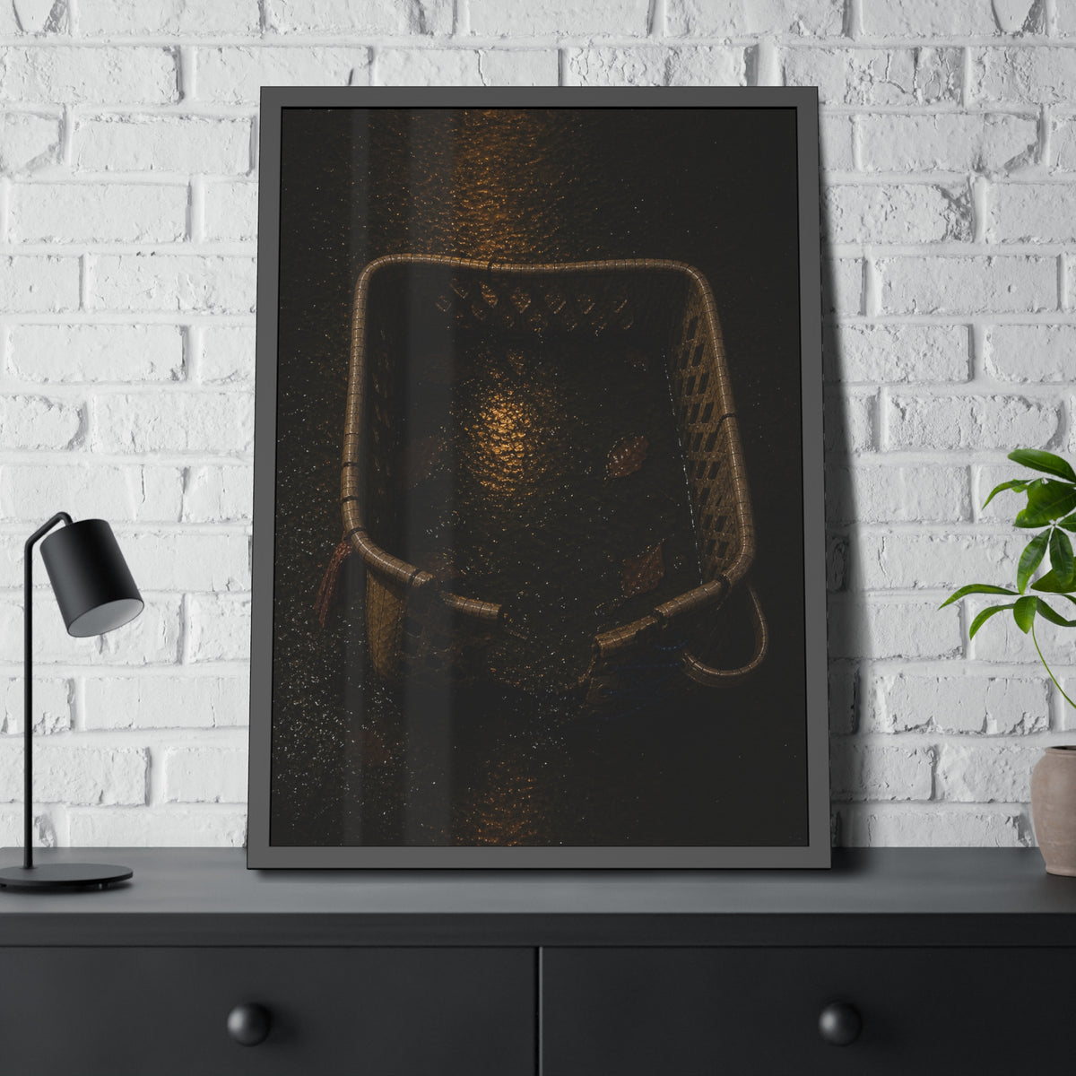 A cracked laundry basket holding rainwater and leaves on wet ground. The Basin of Rain (Laundry Basket) by Garabaggio, framed fine art print hanging in a room.