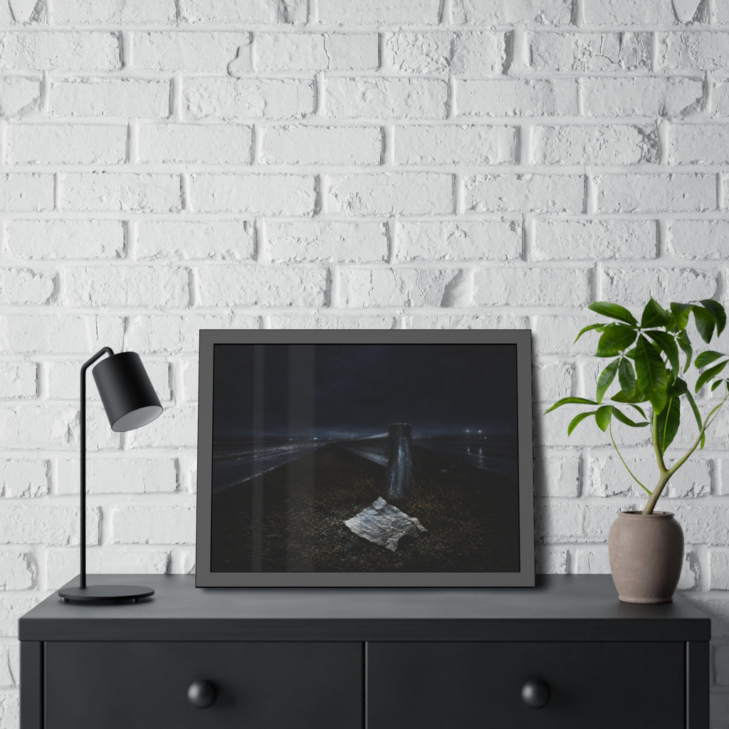 A sheet of paper on a grassy highway median beside a concrete post at night. The Resume on the Median by Garabaggio, framed fine art print hanging in a room.