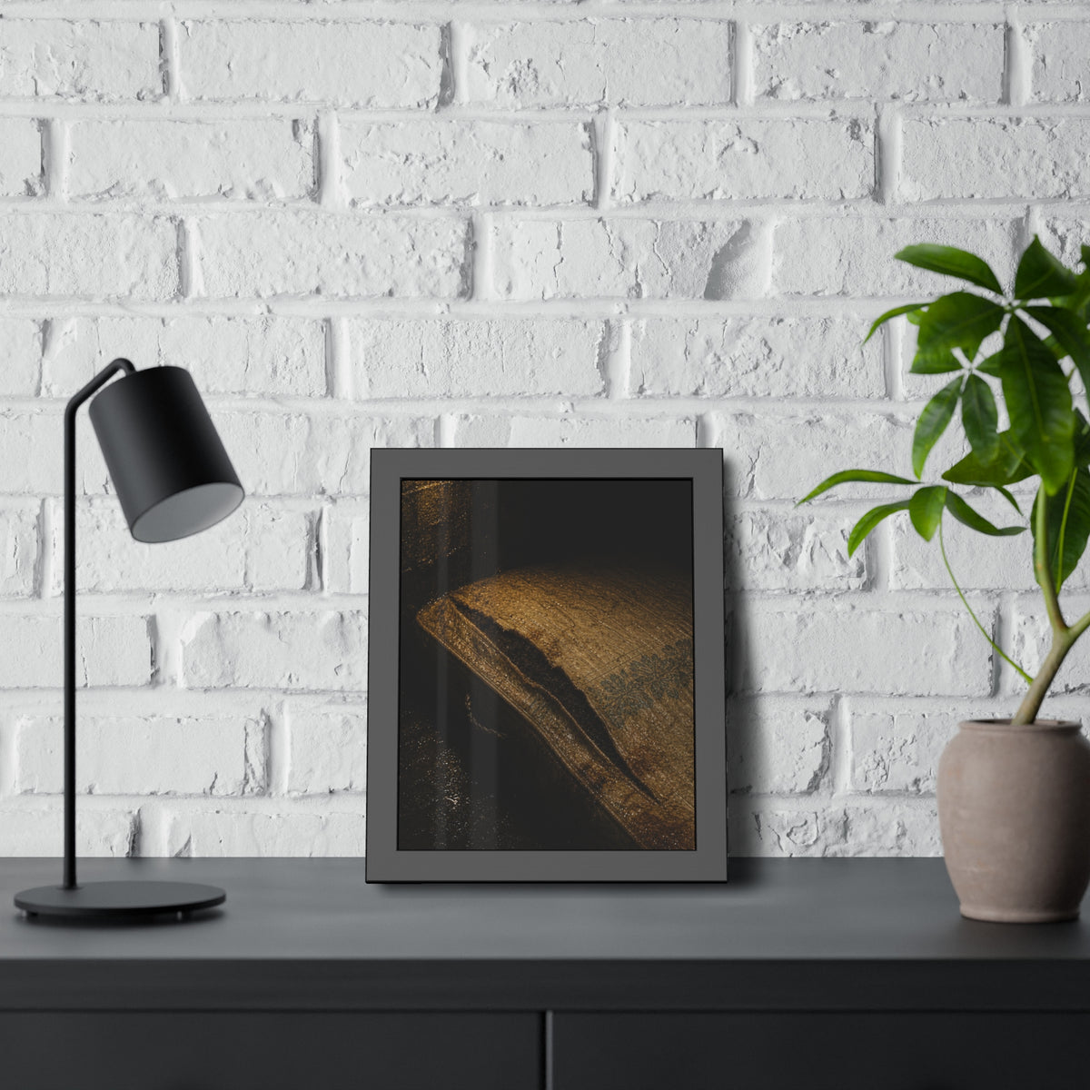 A mattress with its seam split open, lit warm against a dark wall. The Opening of the Ticking by Garabaggio, framed fine art print hanging in a room.
