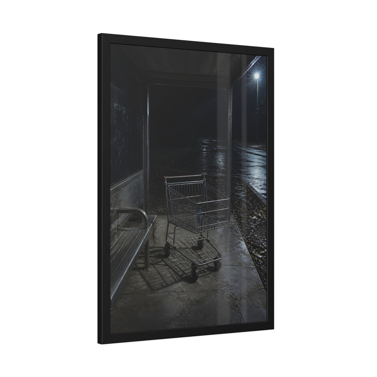 A shopping cart parked inside a bus shelter under a street lamp at night. The Rest at the Bus Shelter by Garabaggio, framed fine art print hanging in a room.