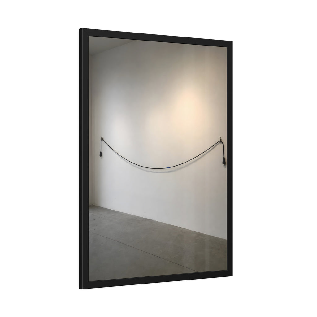 An extension cord hung in a long slack curve across a bare white wall. The Unplugged Line by Garabaggio, framed fine art print hanging in a room.