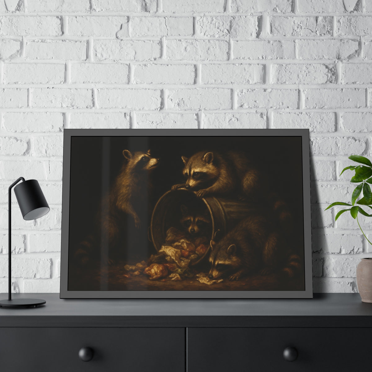 Four raccoons around a tipped metal trash can spilling food scraps. The Crowning with Crumbs by Garabaggio, framed fine art print hanging in a room.