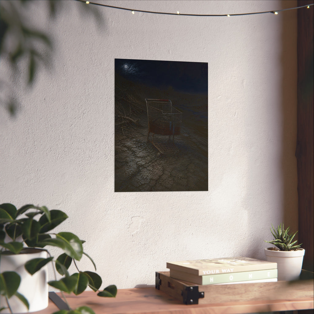 A rusted shopping cart sunk in cracked dried mud under a full moon. The Silting by Garabaggio, fine art print hanging in a room.