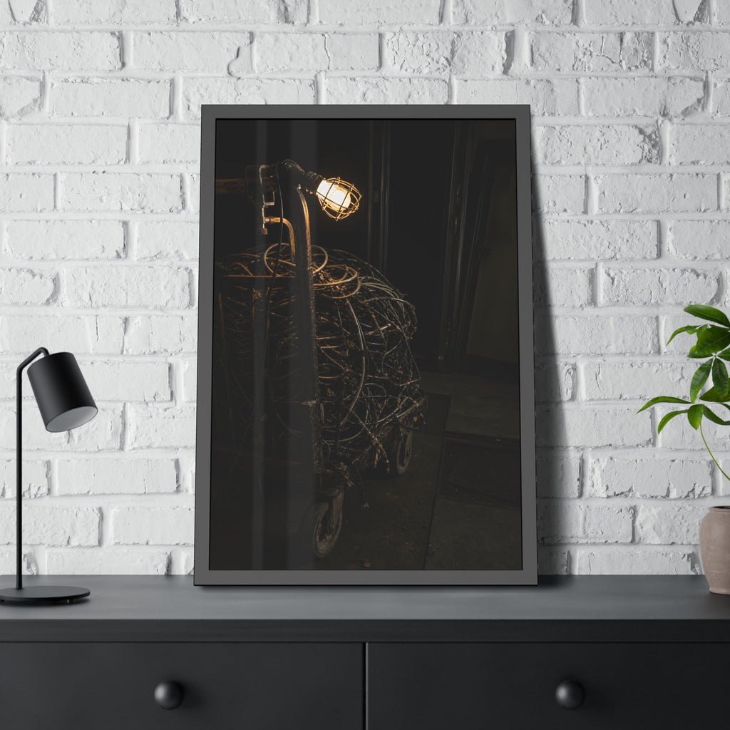 A tangled ball of cables on a hand cart under a caged work lamp. The Cable Harvest by Garabaggio, framed fine art print hanging in a room.