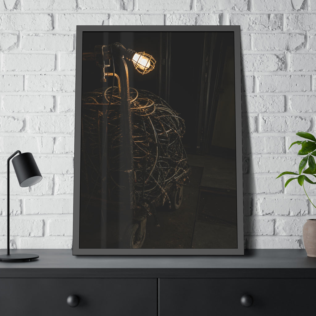 A tangled ball of cables on a hand cart under a caged work lamp. The Cable Harvest by Garabaggio, framed fine art print hanging in a room.