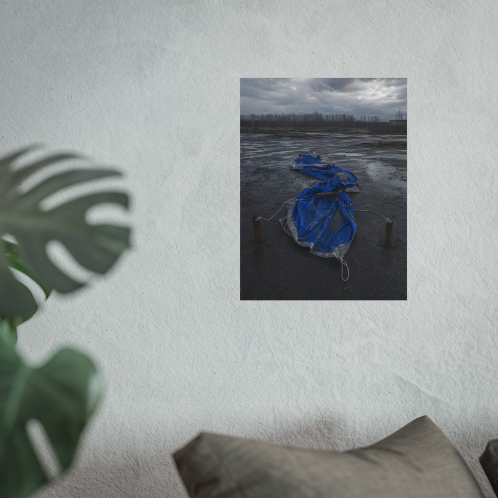 Collapsed blue tarp roped between two posts on wet cracked ground. Collapse Under Wind by Garabaggio, fine art print hanging in a room.