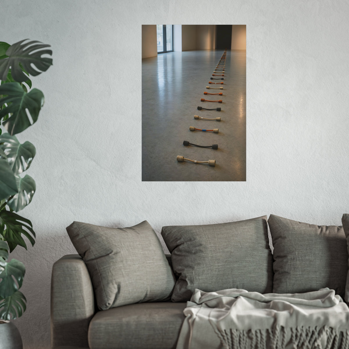 A long line of cut extension cord ends laid across a pale gallery floor. The Severed Procession by Garabaggio, fine art print hanging in a room.