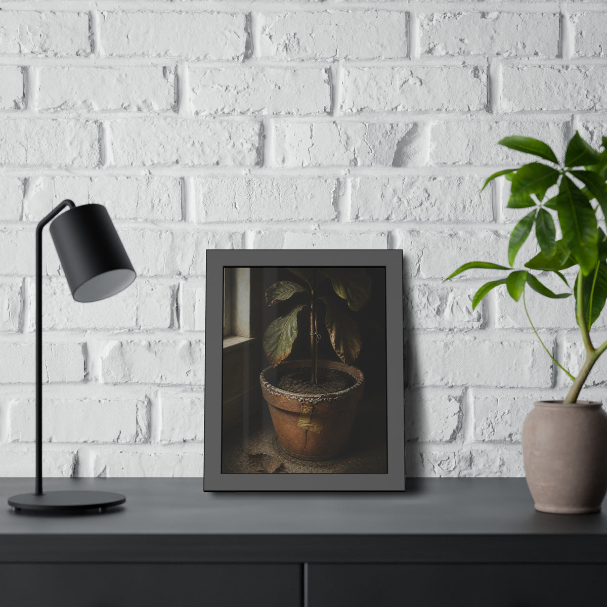 A drooping potted plant in a cracked terracotta pot beside a window. The Missed Watering by Garabaggio, framed fine art print hanging in a room.