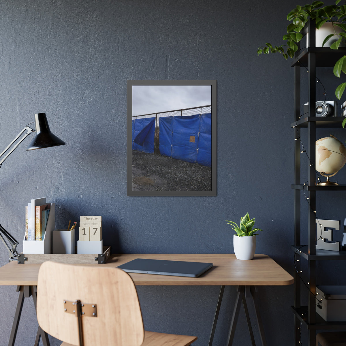 Blue tarps lashed to a chain link fence above gravel under grey sky. Drapery on the Fence by Garabaggio, framed fine art print hanging in a room.