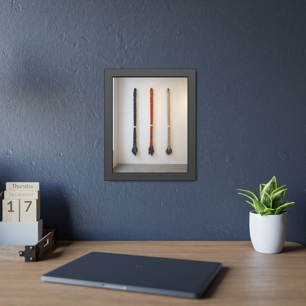 Three braided bundles of extension cords hung on a white gallery wall. The Braided Triptych by Garabaggio, framed fine art print hanging in a room.