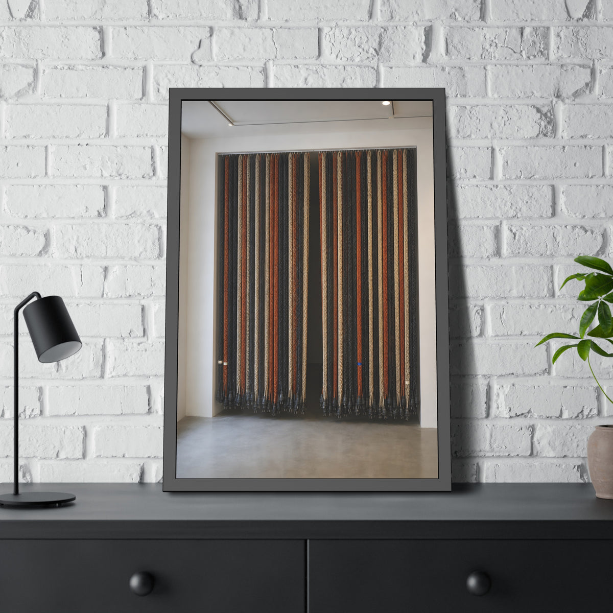 Hundreds of extension cords hung floor to ceiling across a bright white room. The Cord Curtain by Garabaggio, framed fine art print hanging in a room.