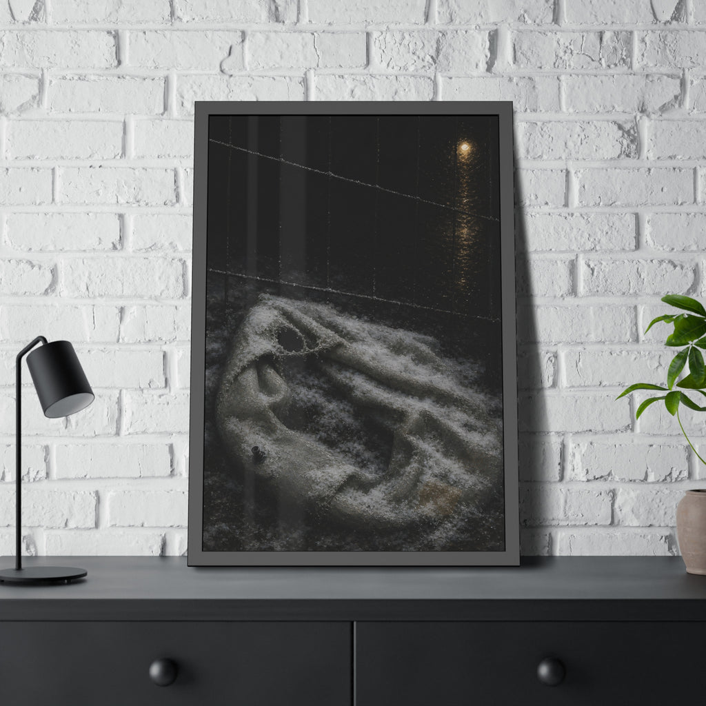 A deflated pool float under snow beside a chain link fence at night. The Bleaching Under Snow by Garabaggio, framed fine art print hanging in a room.