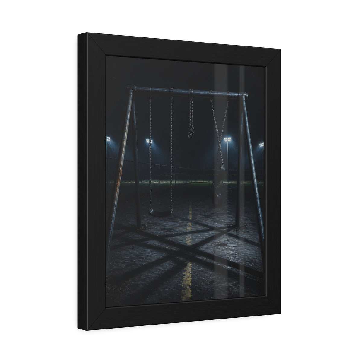 An empty swing set at night with field lights glowing behind it. The Ninth Hour: The Seat Still Moving by Garabaggio, framed fine art print hanging in a room.